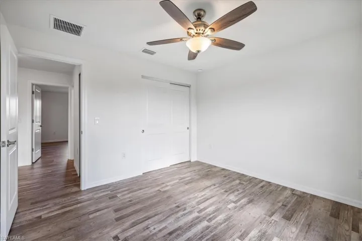 Unfurnished bedroom featuring wood-type flooring, a closet, and ceiling fan