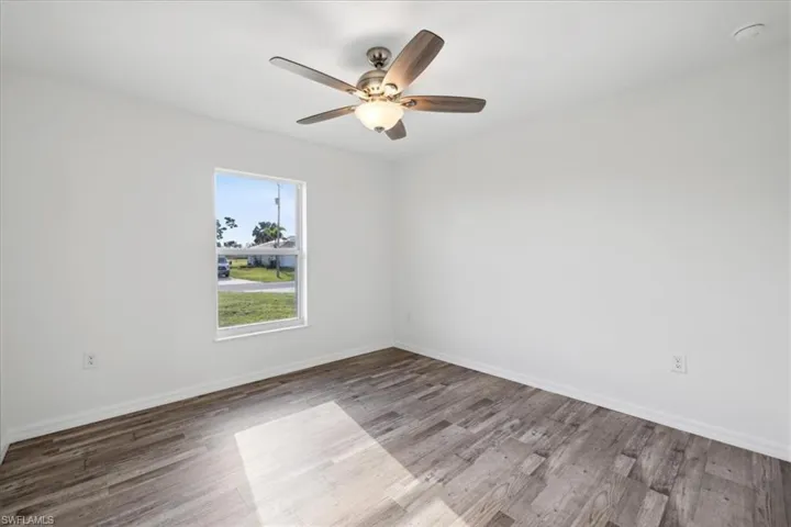 Spare room with wood-type flooring and ceiling fan