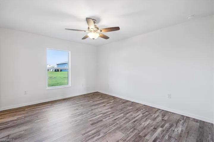 Empty room with hardwood / wood-style flooring and ceiling fan