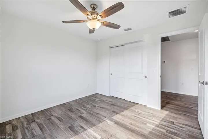 Unfurnished bedroom featuring ceiling fan, a closet, and hardwood / wood-style flooring