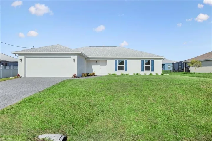 Ranch-style house with a garage and a front lawn