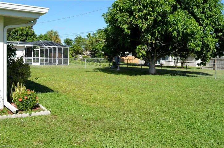 Fenced backyard featuring glass enclosure and a sunroom