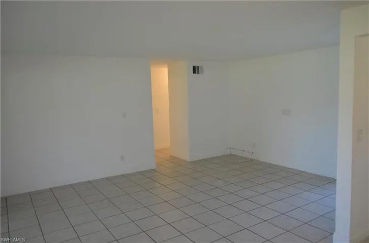 Empty room with baseboards and light tile patterned flooring