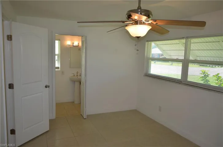 Unfurnished room with a ceiling fan and light tile patterned floors