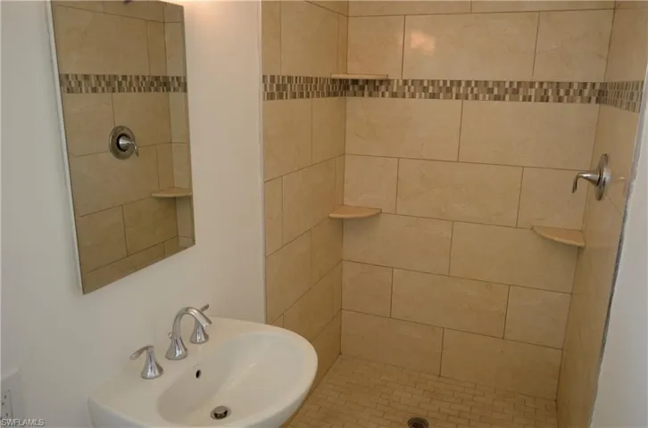 Full bath featuring a sink and a shower stall