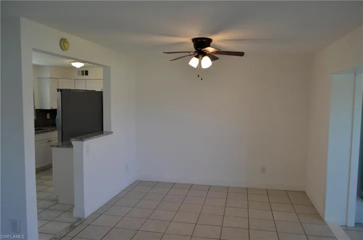 Unfurnished dining area with ceiling fan and light tile patterned floors
