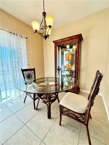 Dining space featuring light tile floors and an inviting chandelier