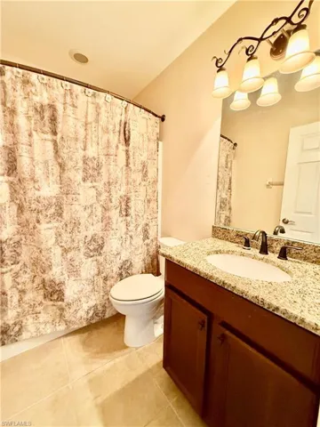 Bathroom featuring tile flooring, vanity, and toilet