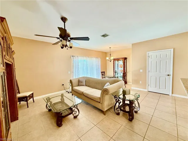 Living room with light tile floors and ceiling fan.