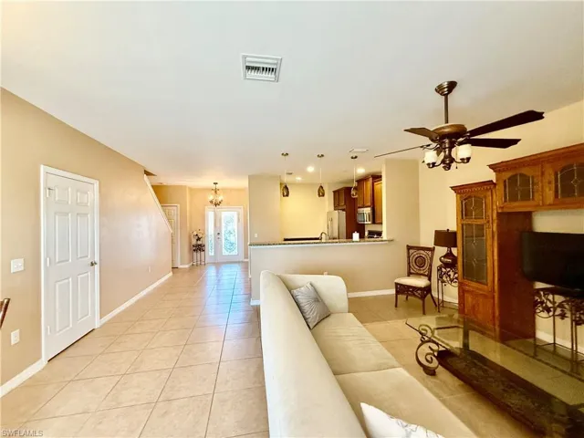 Living room featuring light tile floors and ceiling fan.