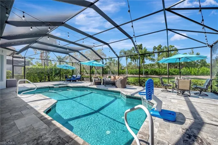 View of pool featuring a sunroom, a patio area, a lanai, and a pool with connected hot tub