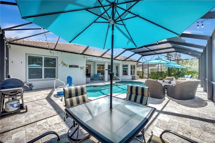 Swimming pool featuring a sunroom, glass enclosure, a patio area, outdoor dining space, and an outdoor living space