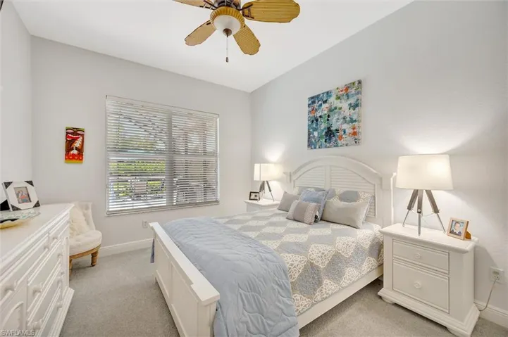 Bedroom with light colored carpet and a ceiling fan