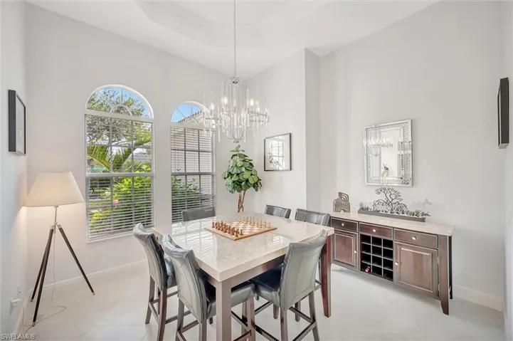 Dining space featuring a tray ceiling, a chandelier, and crown molding