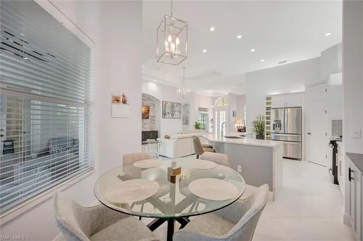 Dining area with recessed lighting, a chandelier, a raised ceiling, and light tile patterned floors