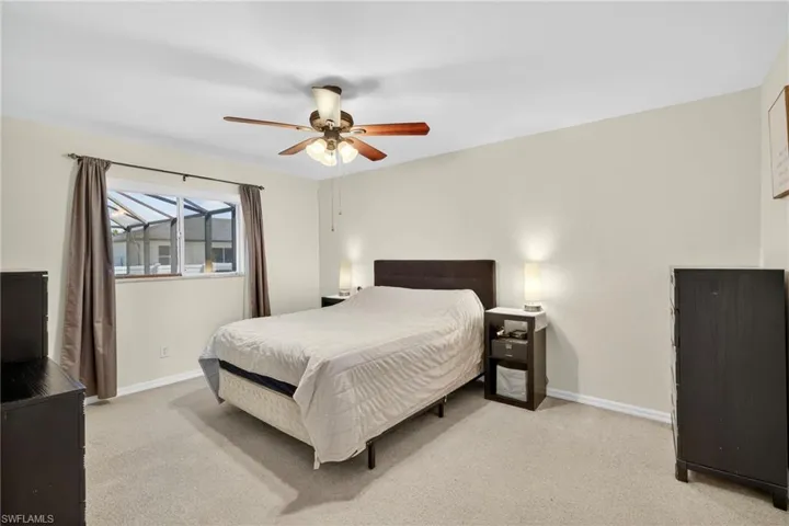 Bedroom with light carpet and a ceiling fan
