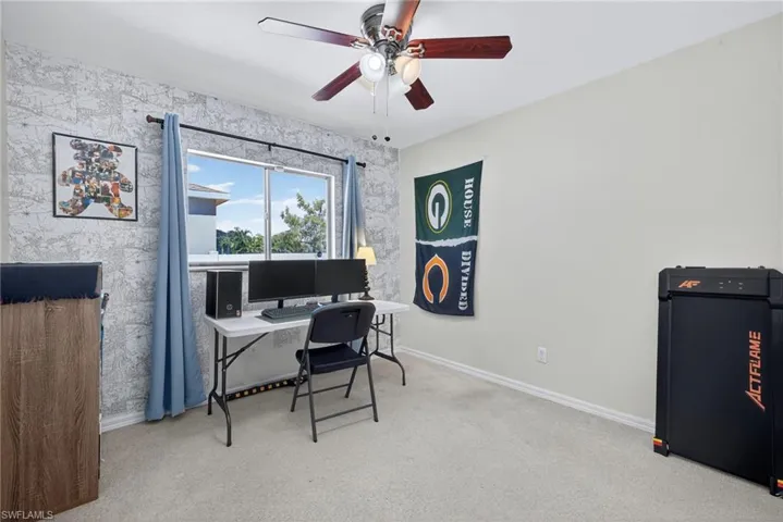 Bedroom w/ light colored carpet and a ceiling fan