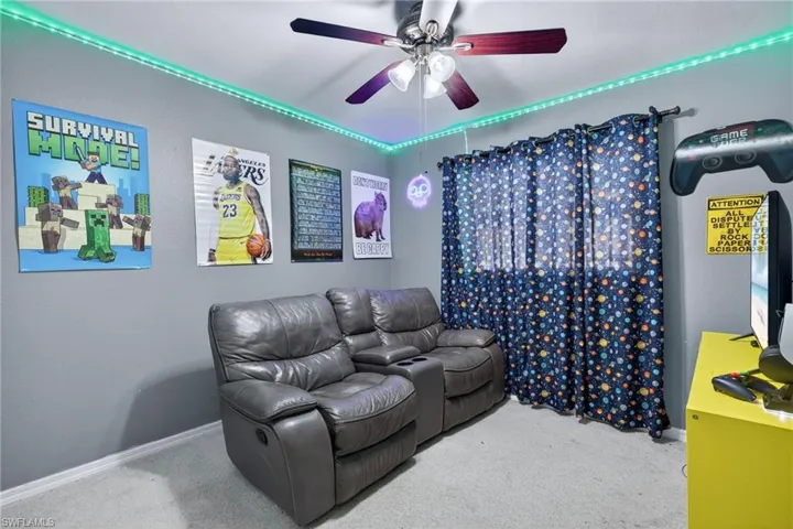 Carpeted bedroom featuring a ceiling fan and baseboards
