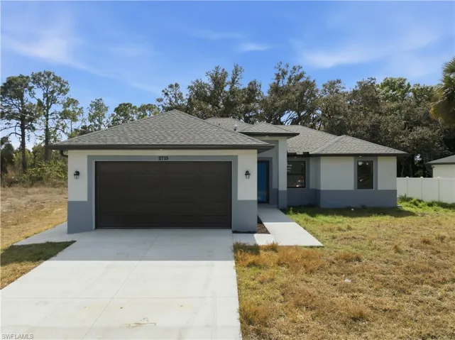 View of front of home with an attached garage, stucco siding, driveway, and a shingled roof