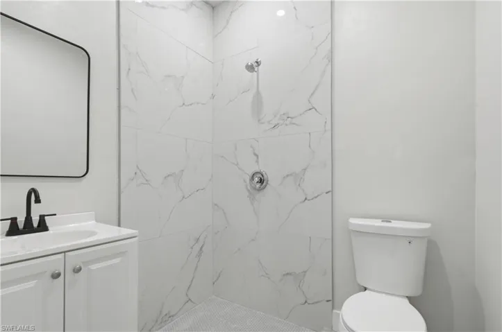 Full bathroom with vanity and a marble finish shower