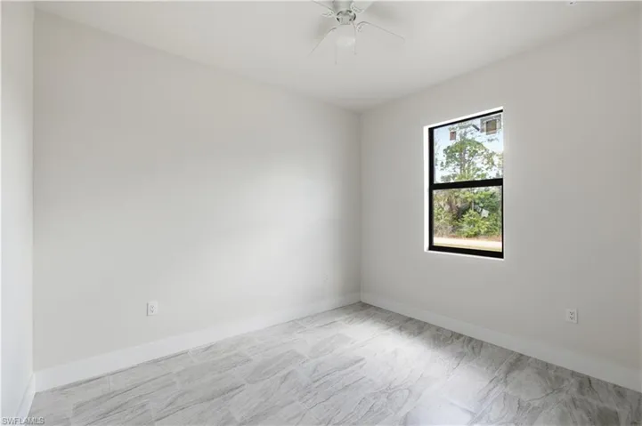 Empty room featuring baseboards and a ceiling fan