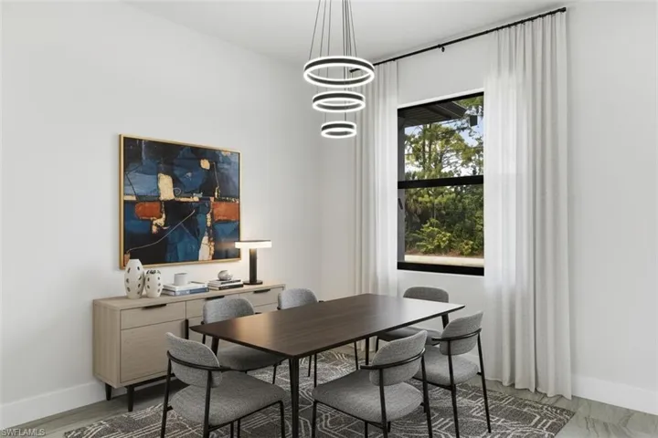 Dining space featuring baseboards and suspended lighting