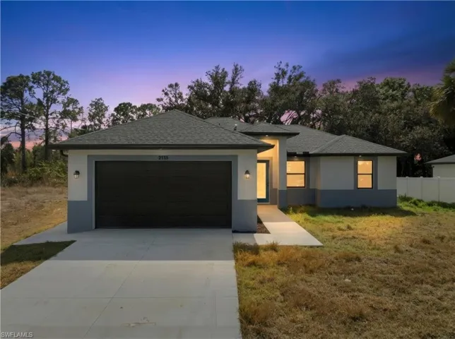 View of front of home featuring stucco siding, a garage, concrete driveway, and a shingled roof