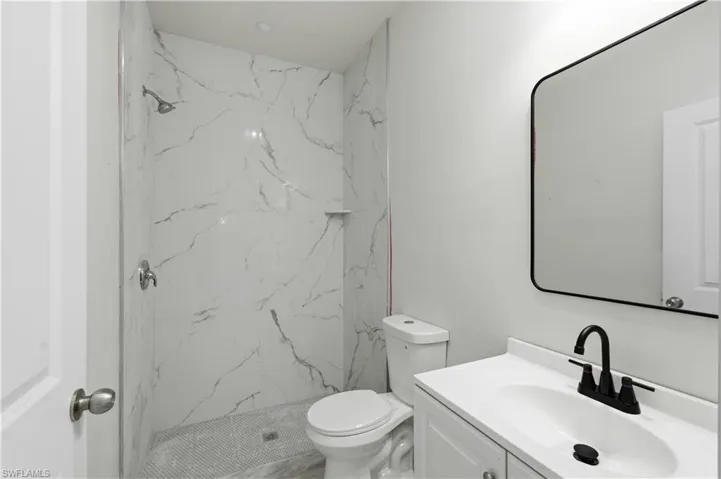 Full bath with vanity and a marble finish shower