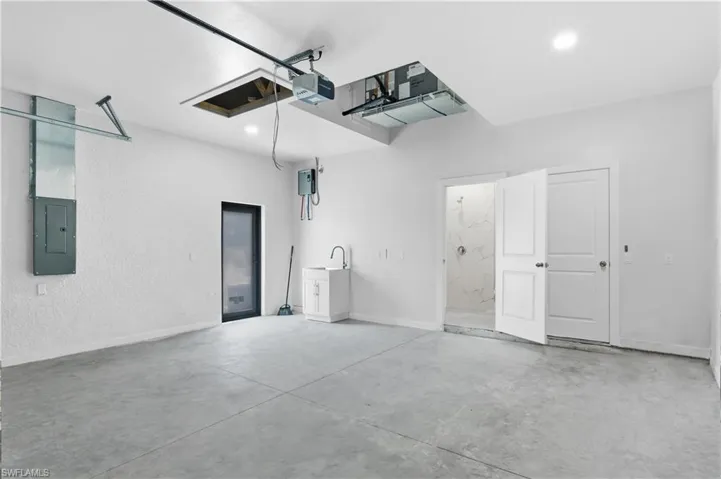 Garage with electric panel and a garage door opener