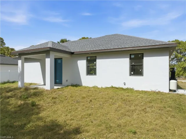 Back of property featuring stucco siding and roof with shingles