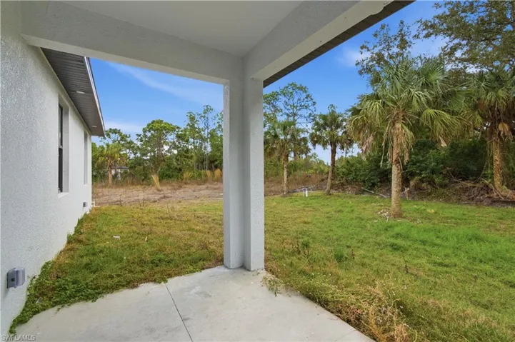 View of green lawn with a patio area