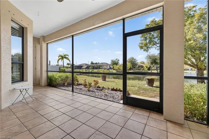 Sunroom with textured wall, canal views, and abundant natural light.