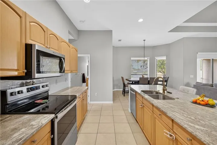Full stainless-steel appliance suite (2019) paired with Level 4 River White granite, recessed lighting, and designer light fixtures.