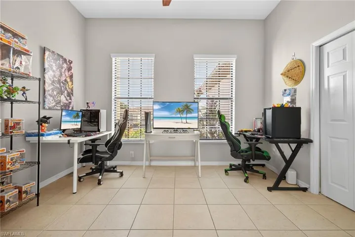 Bright den filled with natural light and light tile flooring. Ideal as a home office, study, or flex space.