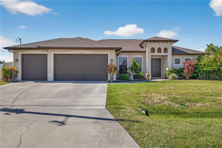 Mediterranean-style Tundra-built home with stucco exterior, oversized 3-car garage, concrete driveway, and tiled front porch.