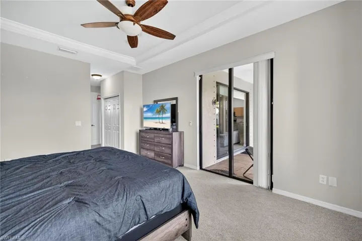 Comfortable bedroom with generous closet, ceiling fan, carpet flooring, and direct exterior access.