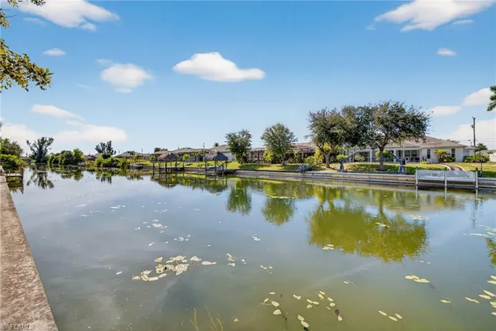 Tranquil freshwater canal view with mature landscaping and serene water frontage.