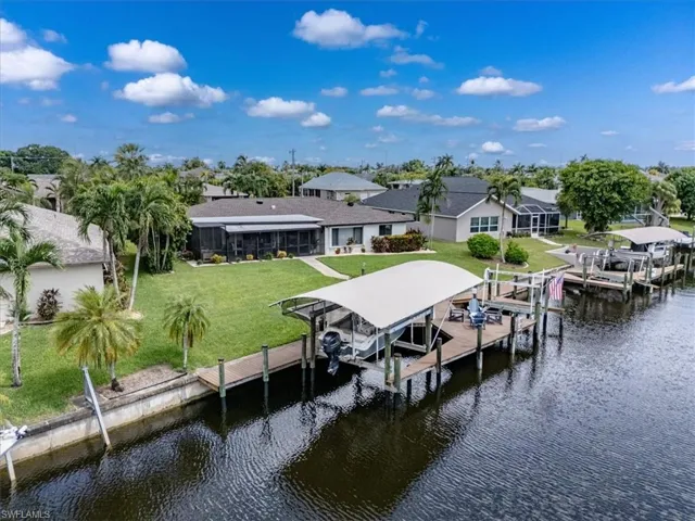 View of dock with a yard and a water view