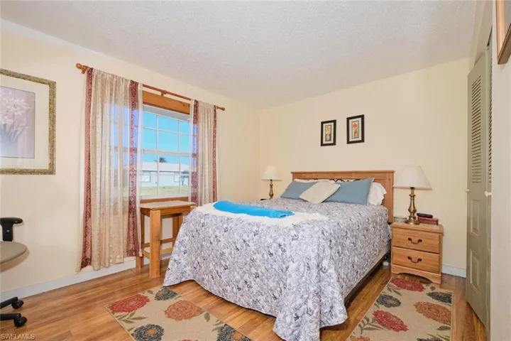 Bedroom featuring wood-type flooring, a textured ceiling, and a closet
