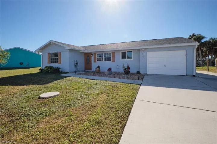 Ranch-style house featuring a garage and a front yard