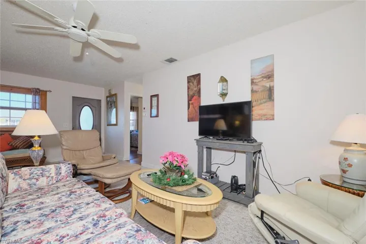 Living room featuring ceiling fan and a textured ceiling