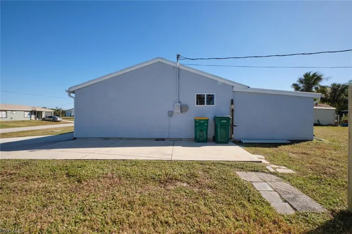 Back of property with a lawn and a patio