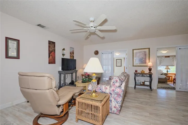 Living room featuring french doors, a textured ceiling, light hardwood / wood-style flooring, and ceiling fan