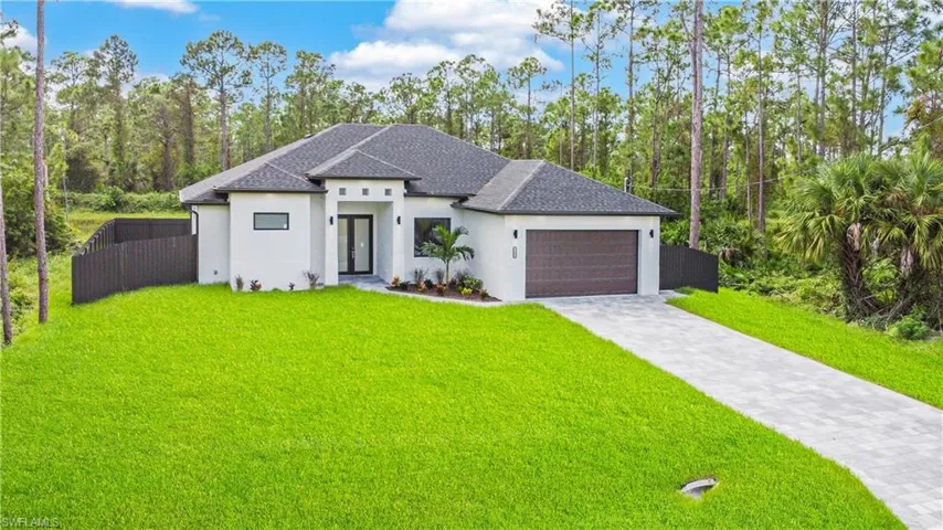 View of front facade featuring a front yard and a garage