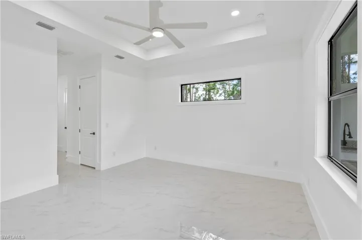 Spare room with ceiling fan and a raised ceiling