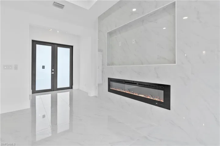 Foyer with french doors and a high end fireplace