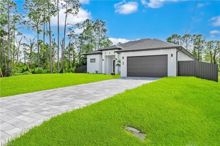 View of front of property featuring a front yard and a garage