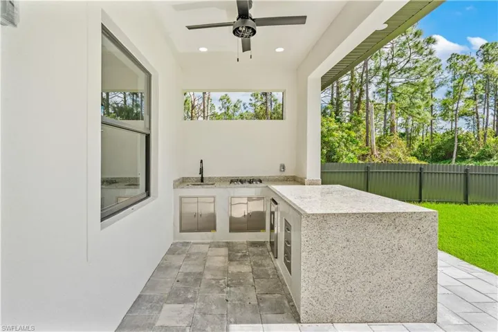 View of patio / terrace featuring ceiling fan, sink, and exterior kitchen
