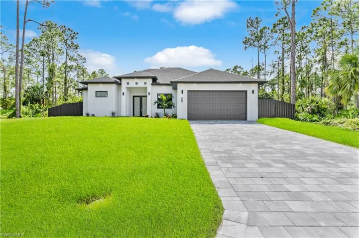 Prairie-style home with a garage and a front lawn