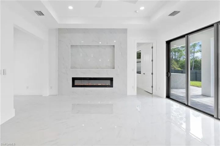 Unfurnished living room with a fireplace and a tray ceiling